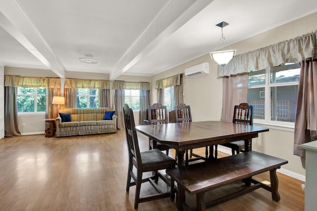 dining space with a wall mounted air conditioner, beam ceiling, crown molding, and hardwood / wood-style floors