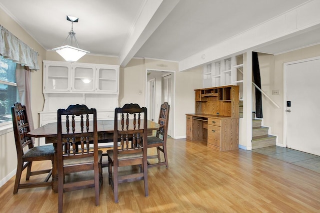 dining area with light hardwood / wood-style floors and crown molding