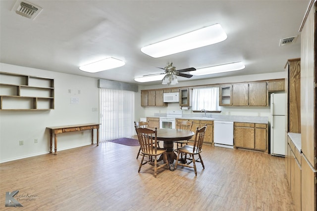 dining room with ceiling fan, light wood-type flooring, and sink