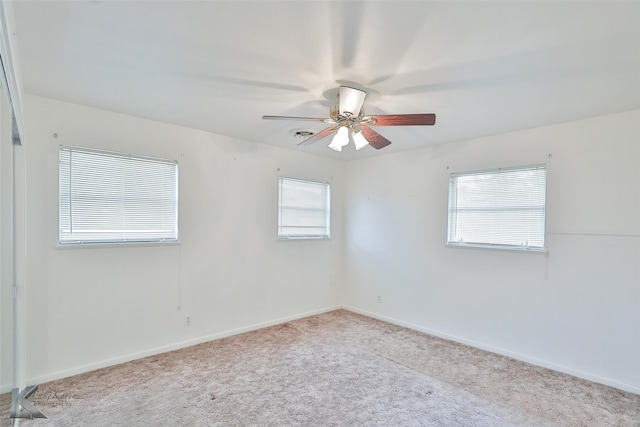 empty room featuring ceiling fan and light colored carpet