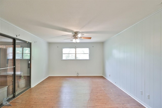 unfurnished room featuring ceiling fan, hardwood / wood-style floors, and ornamental molding