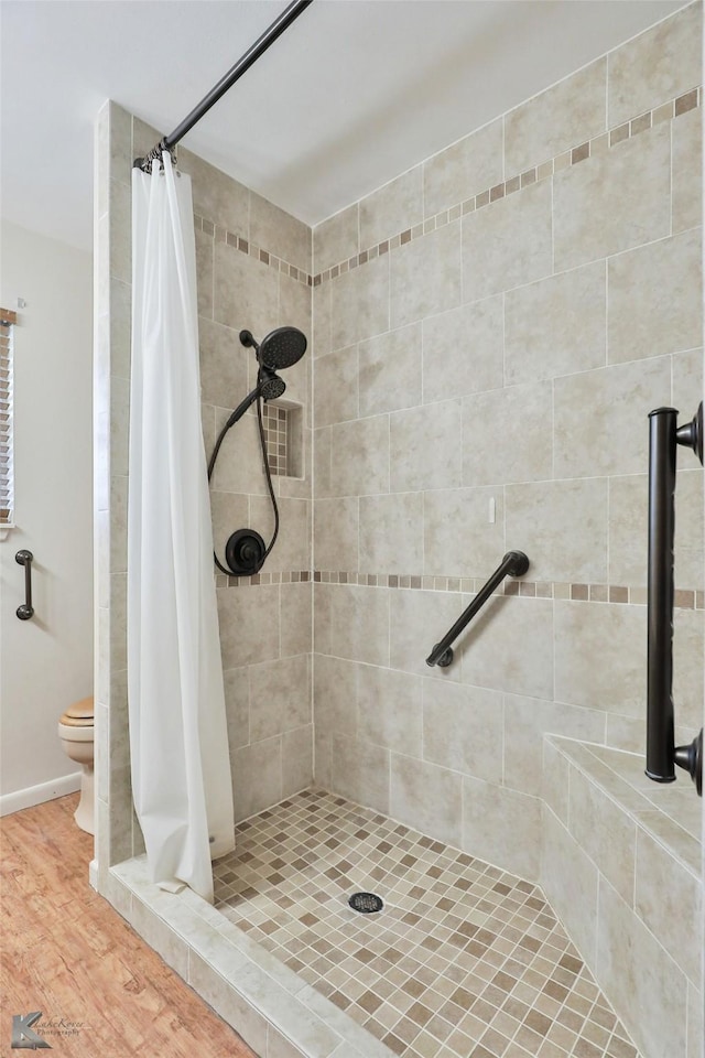 bathroom with a shower with curtain, toilet, and hardwood / wood-style floors