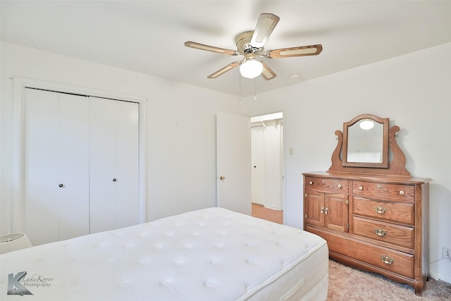 bedroom featuring ceiling fan, a closet, and light carpet