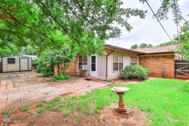 rear view of house with a patio area, a yard, cooling unit, and a storage shed