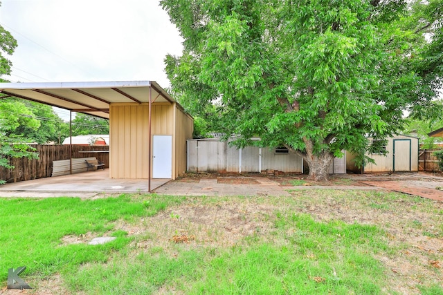 view of yard with a storage shed and a patio