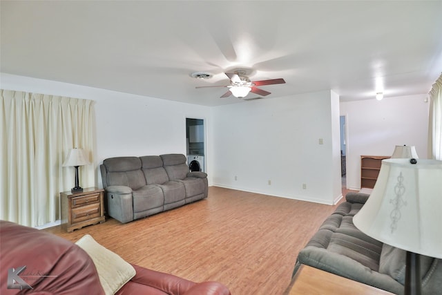 living room featuring ceiling fan, hardwood / wood-style floors, and washer / dryer