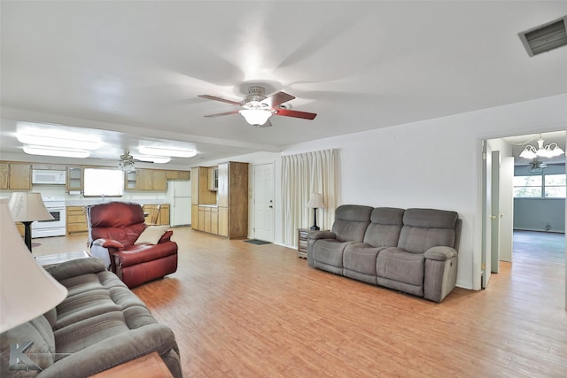 living room featuring light hardwood / wood-style flooring and ceiling fan with notable chandelier