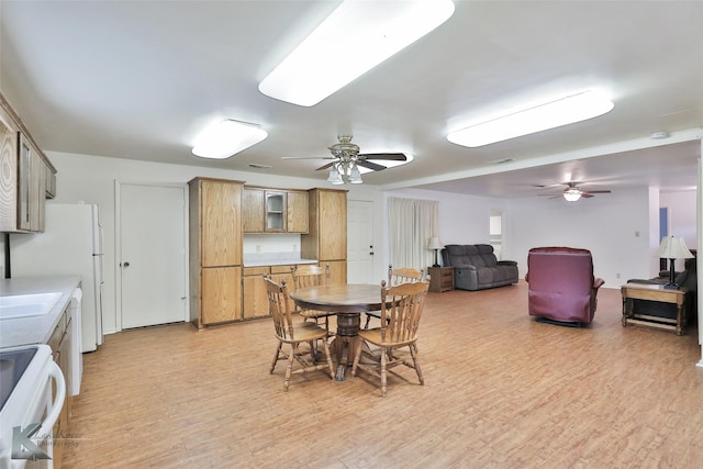 dining area with ceiling fan and light wood-type flooring