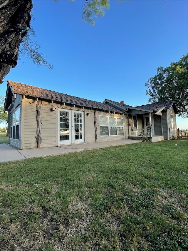 back of property featuring french doors and a yard