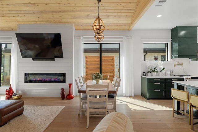 dining space featuring lofted ceiling, wood ceiling, a fireplace, and light hardwood / wood-style floors