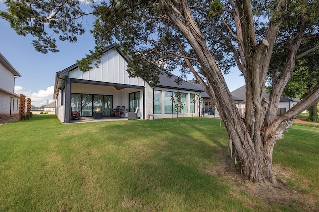 rear view of property featuring a patio and a lawn