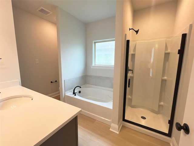 bathroom featuring vanity, wood-type flooring, and independent shower and bath