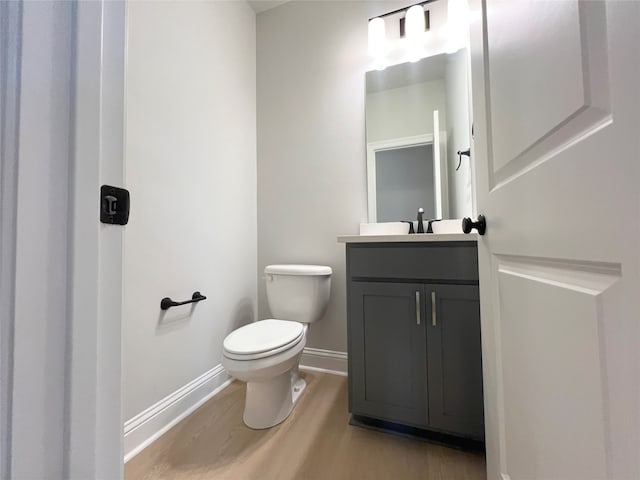 bathroom featuring vanity, toilet, and hardwood / wood-style flooring