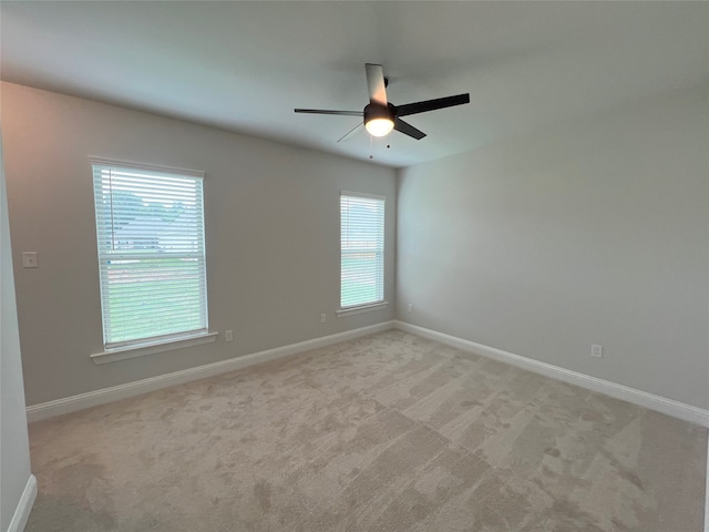 empty room featuring light colored carpet, plenty of natural light, and ceiling fan