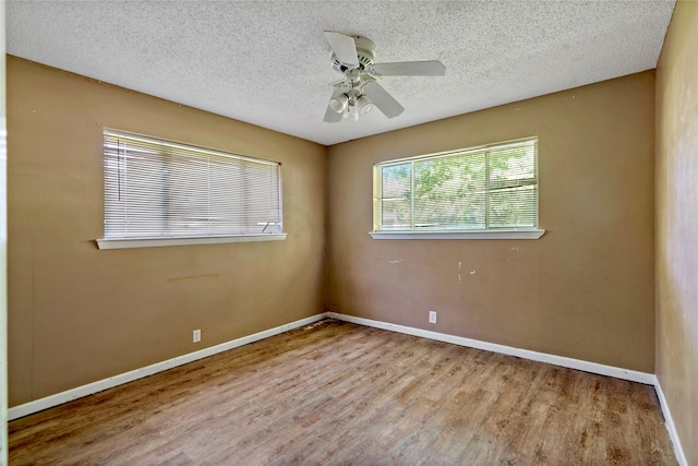 spare room featuring ceiling fan, light hardwood / wood-style floors, and a textured ceiling