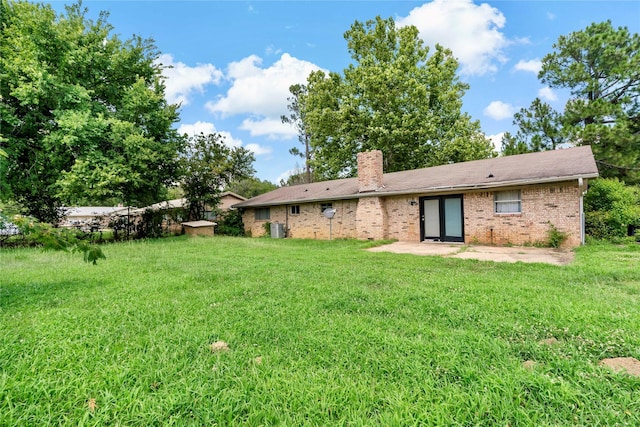 rear view of property featuring a patio area and a yard