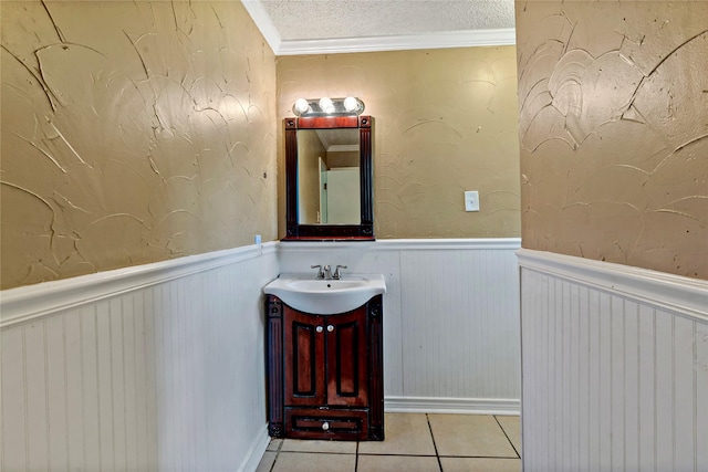 bathroom with tile patterned flooring, vanity, a textured ceiling, and ornamental molding