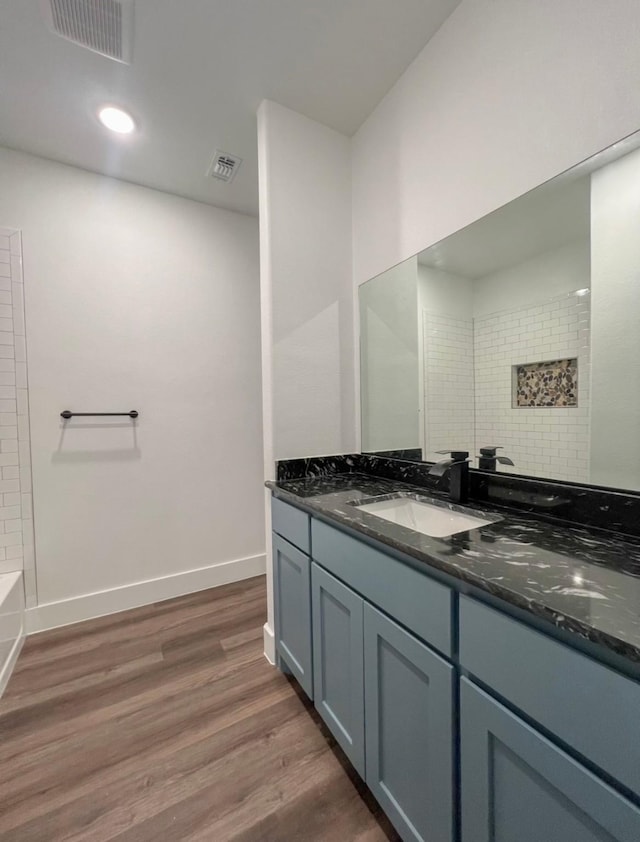 bathroom featuring hardwood / wood-style floors, vanity, and shower / bathing tub combination