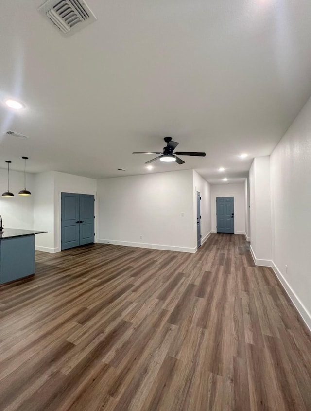 unfurnished living room with dark hardwood / wood-style floors and ceiling fan