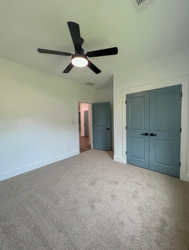 unfurnished bedroom featuring carpet flooring, ceiling fan, and a closet