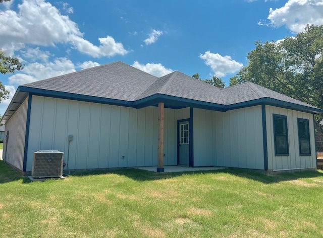 view of front of house with a front yard and cooling unit