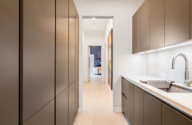 kitchen featuring backsplash, sink, and gray cabinetry