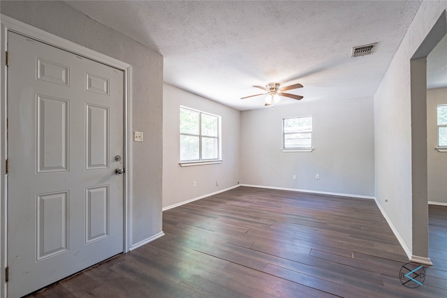 interior space with ceiling fan, a textured ceiling, and dark hardwood / wood-style flooring