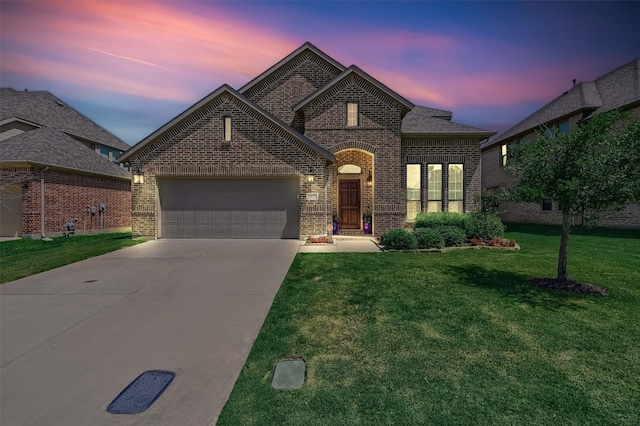 french provincial home with a garage and a lawn