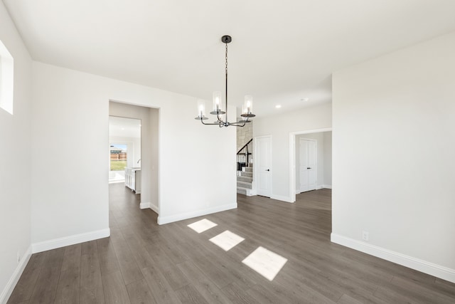 unfurnished dining area with dark hardwood / wood-style flooring and an inviting chandelier