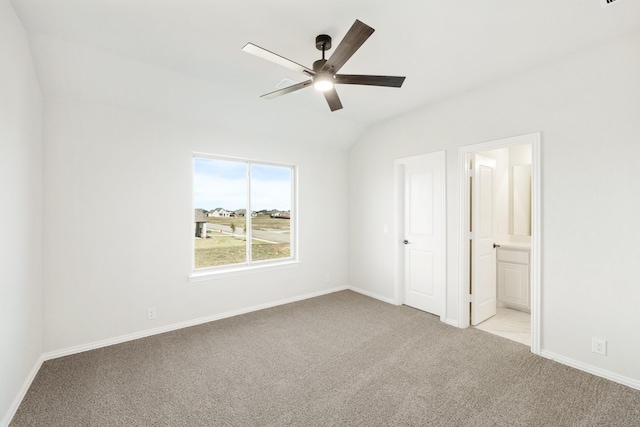 unfurnished bedroom featuring vaulted ceiling, light carpet, ceiling fan, and ensuite bathroom