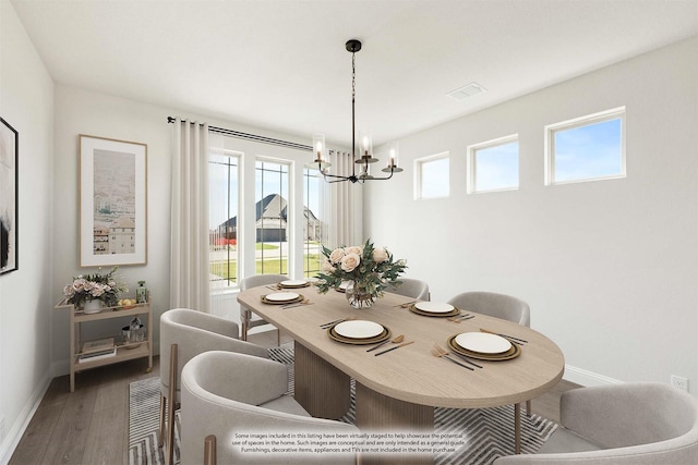 dining space with hardwood / wood-style flooring, a wealth of natural light, and an inviting chandelier