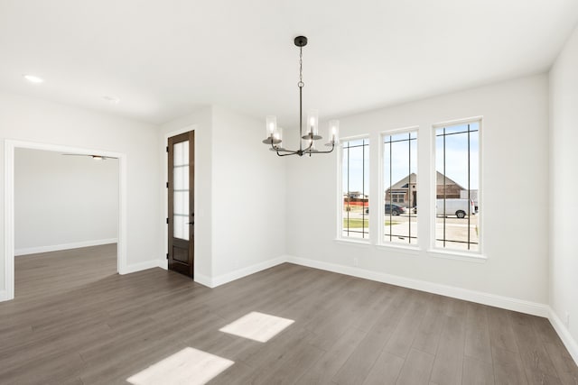 unfurnished dining area with dark hardwood / wood-style flooring and an inviting chandelier