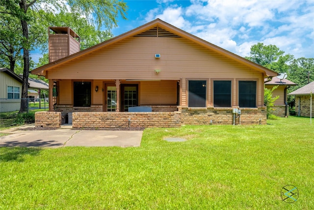 rear view of house with a lawn and a patio