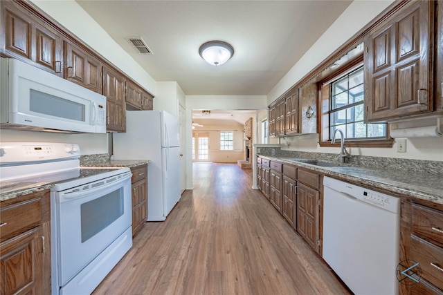 kitchen featuring sink, white appliances, and light hardwood / wood-style floors