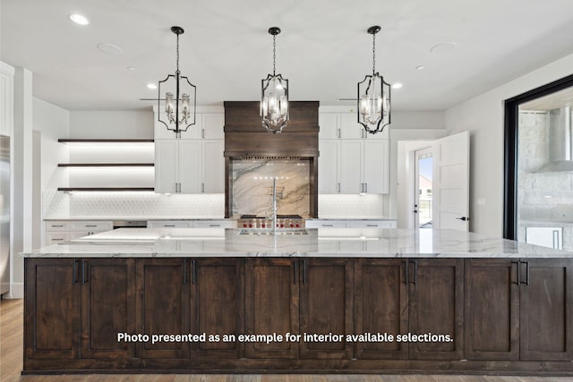 kitchen with a large island, decorative backsplash, and white cabinetry