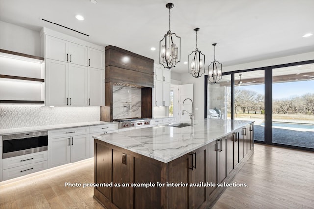 kitchen featuring white cabinets, dark brown cabinets, and a center island with sink