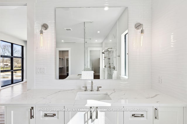 bathroom featuring vanity and tiled shower