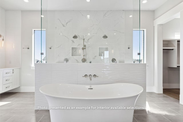 bathroom featuring tile patterned flooring, vanity, shower with separate bathtub, and tile walls