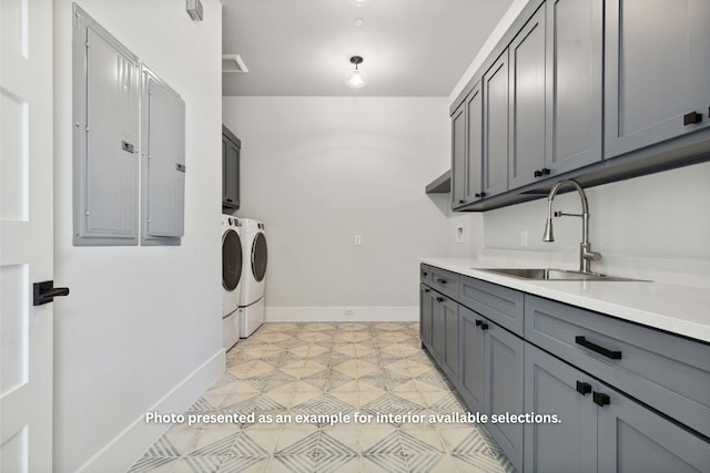 clothes washing area featuring electric panel, sink, cabinets, and independent washer and dryer