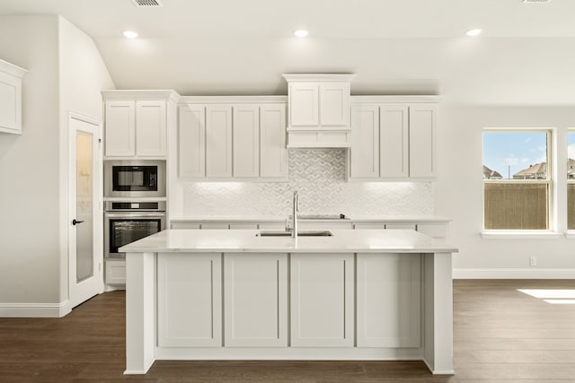 kitchen with black microwave, white cabinets, stainless steel oven, dark hardwood / wood-style floors, and sink