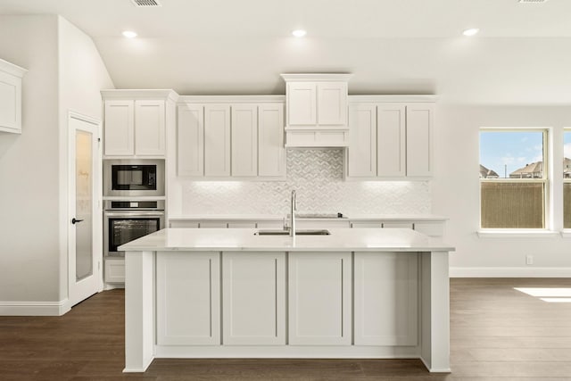 kitchen with a sink, light countertops, stainless steel oven, built in microwave, and tasteful backsplash