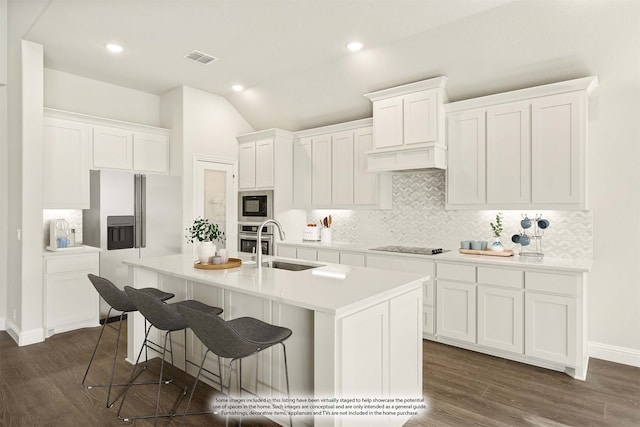 kitchen with black appliances, a kitchen island with sink, and white cabinets