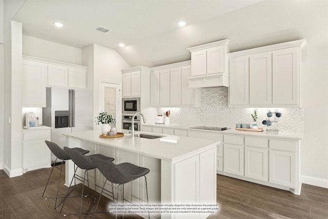 kitchen with a sink, decorative backsplash, built in microwave, and refrigerator with ice dispenser