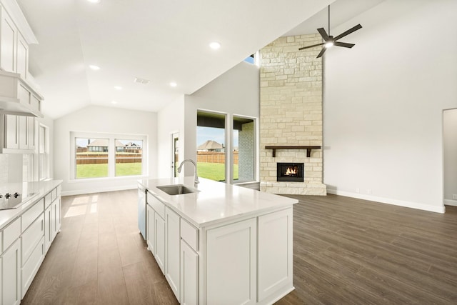kitchen featuring open floor plan, ceiling fan, dark wood-style floors, white cabinets, and a sink