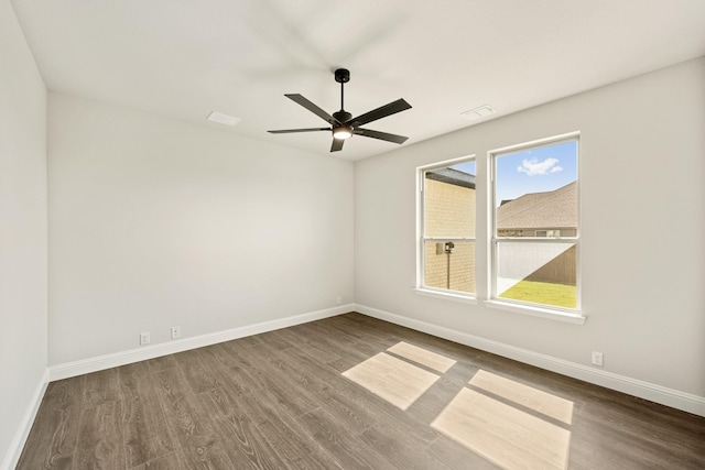 spare room with plenty of natural light, baseboards, ceiling fan, and wood finished floors