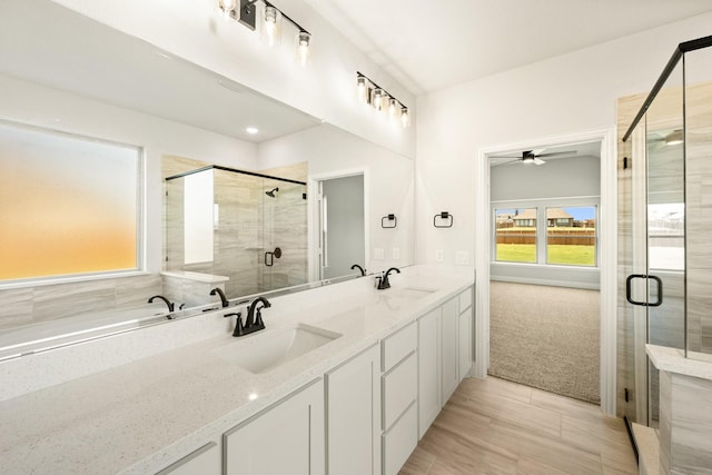 full bathroom with a sink, a ceiling fan, a stall shower, and double vanity