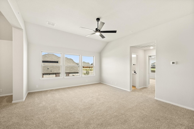 unfurnished room with light colored carpet, a ceiling fan, baseboards, lofted ceiling, and visible vents