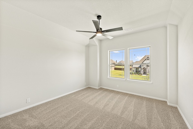 carpeted spare room with a textured ceiling and ceiling fan