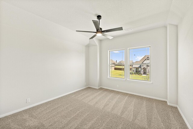 empty room with baseboards, ceiling fan, light carpet, and visible vents