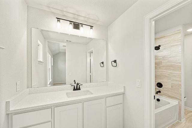 bathroom with vanity and tiled shower / bath combo